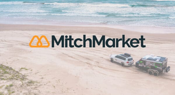 MitchMarket Marketplace logo on a photo of a beach and a 4WD towing a caravan
